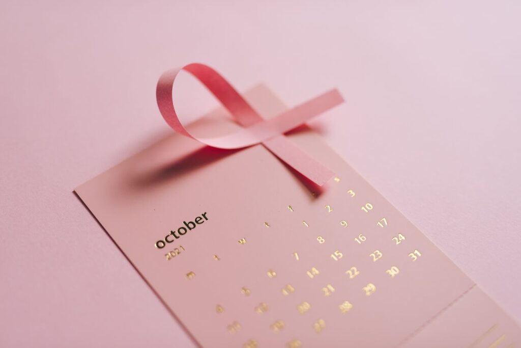 Close-up of a pink ribbon and October calendar promoting breast cancer awareness.