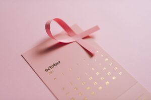 Close-up of a pink ribbon and October calendar promoting breast cancer awareness.
